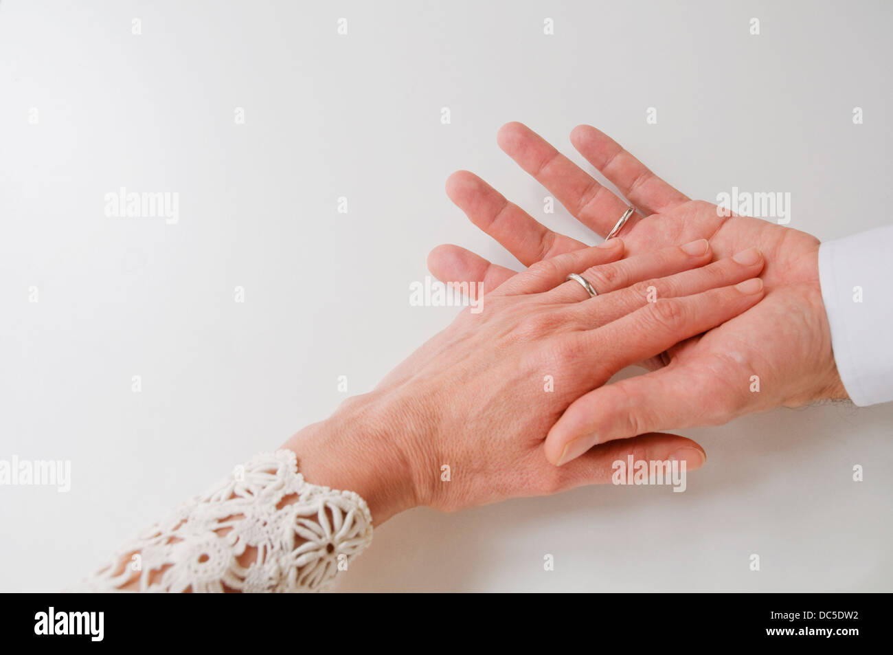Mature couple's hands wearing wedding rings. Stock Photo