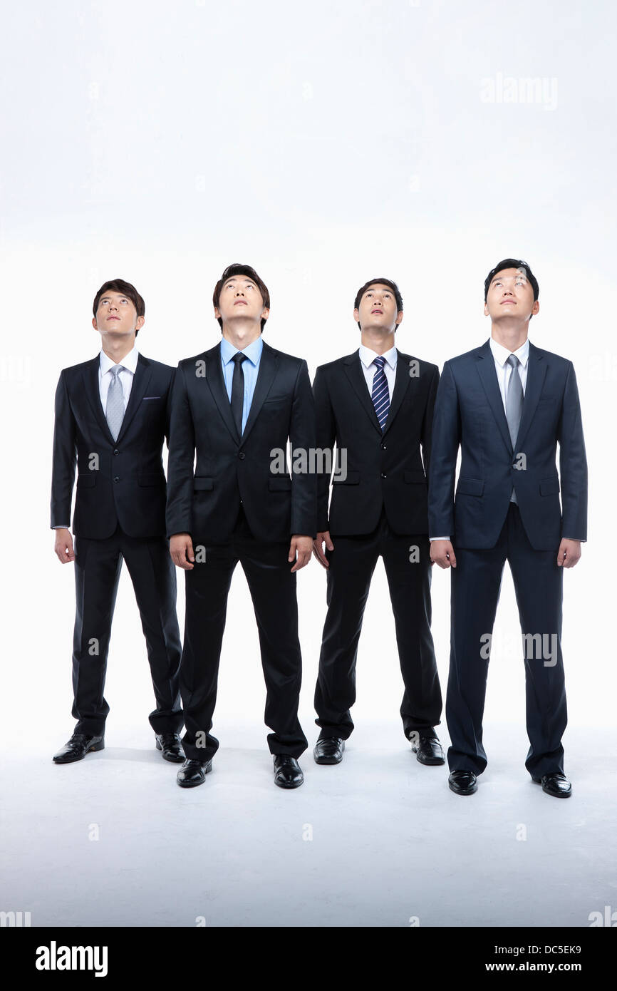 four businessmen looking up while standing in a line Stock Photo - Alamy