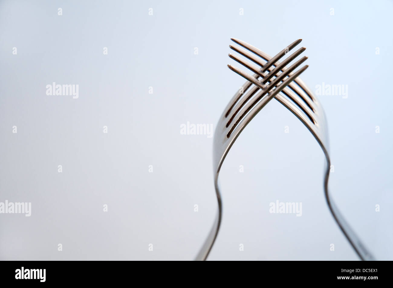 Two interlaced forks. Close view. Stock Photo