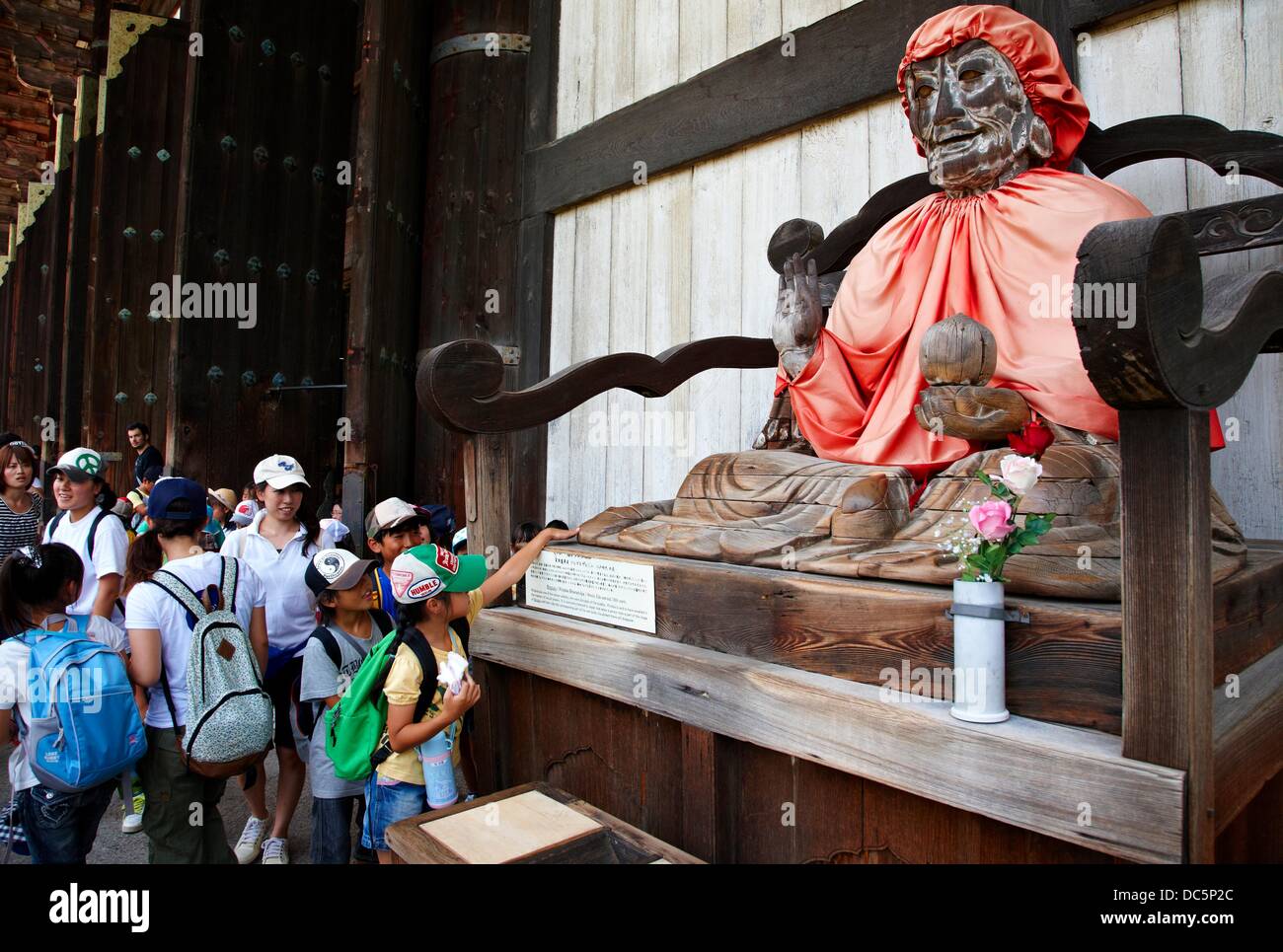 Children, Jizo Buddha statue dressed in red cape, Todaiji Temple, Nara