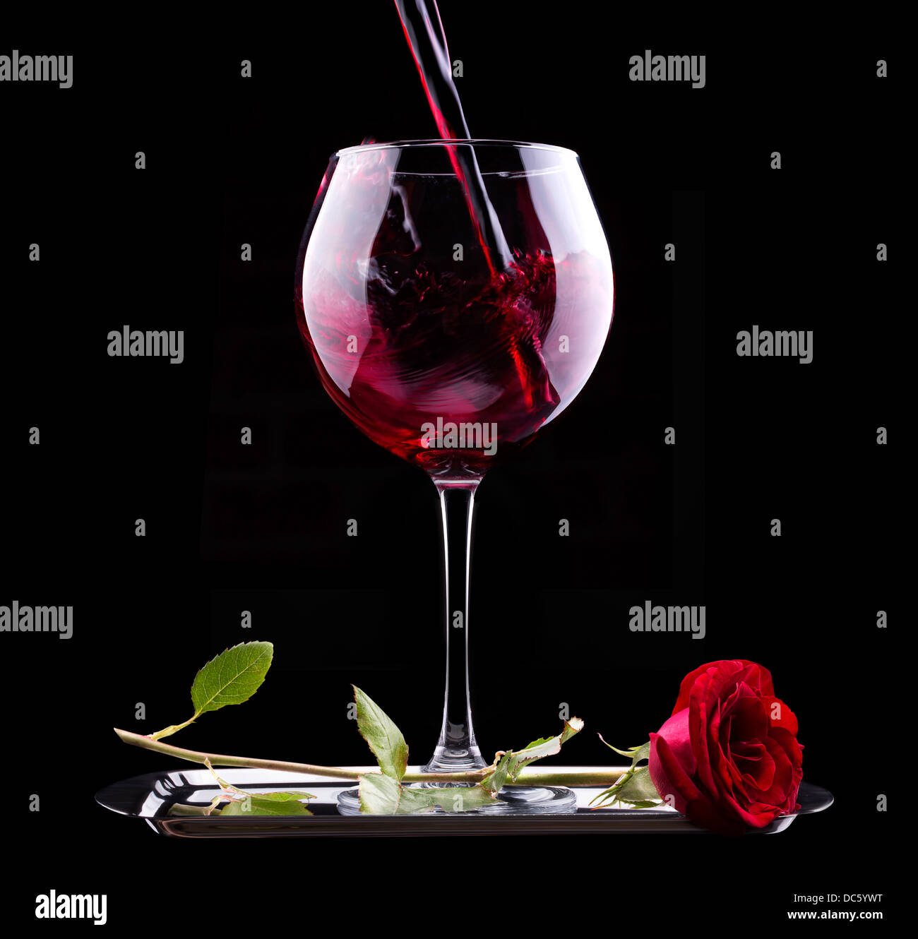 glass of red wine and red rose on black background Stock Photo - Alamy