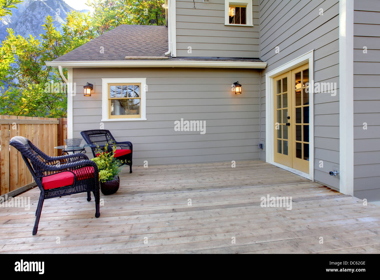 deck-with-two-chairs-and-fenced-back-yard-near-home-exterior-shot-stock