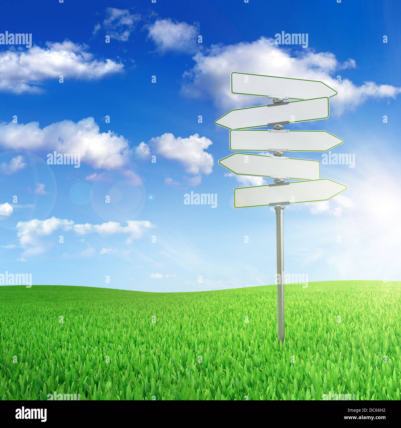 Road sign in the middle of green field with cloudy sky on background ...