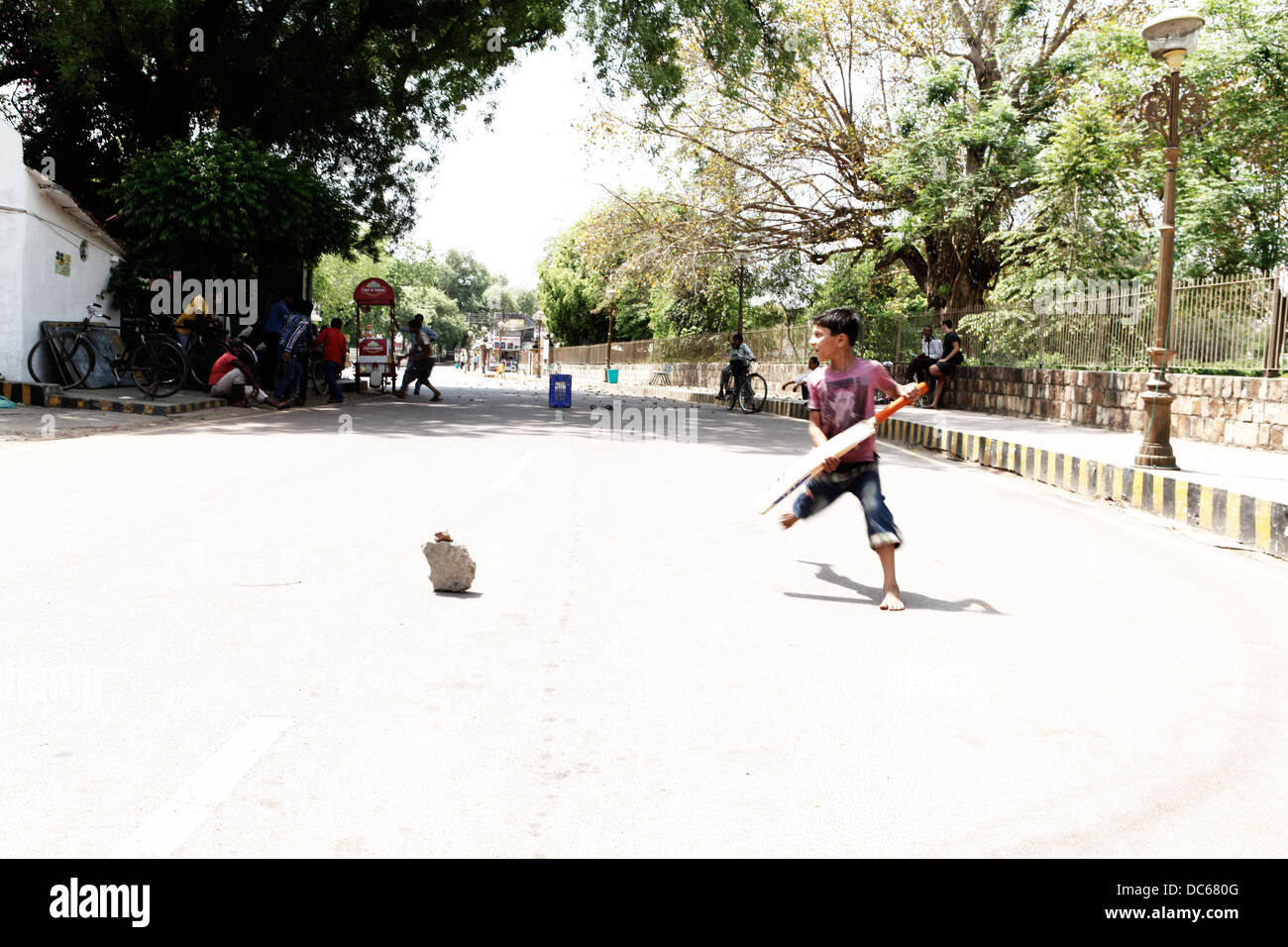 A young Indian boy runs a quick single during a game of street cricket in Khajuraho, India. Stock Photo