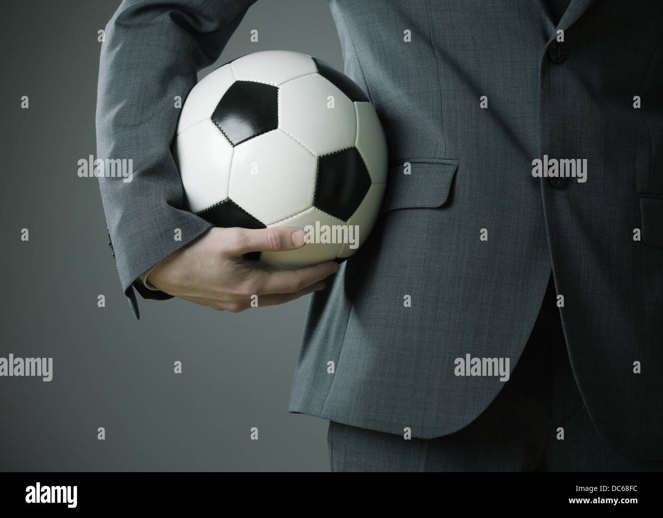 Elegant businessman holding a soccer ball Stock Photo - Alamy