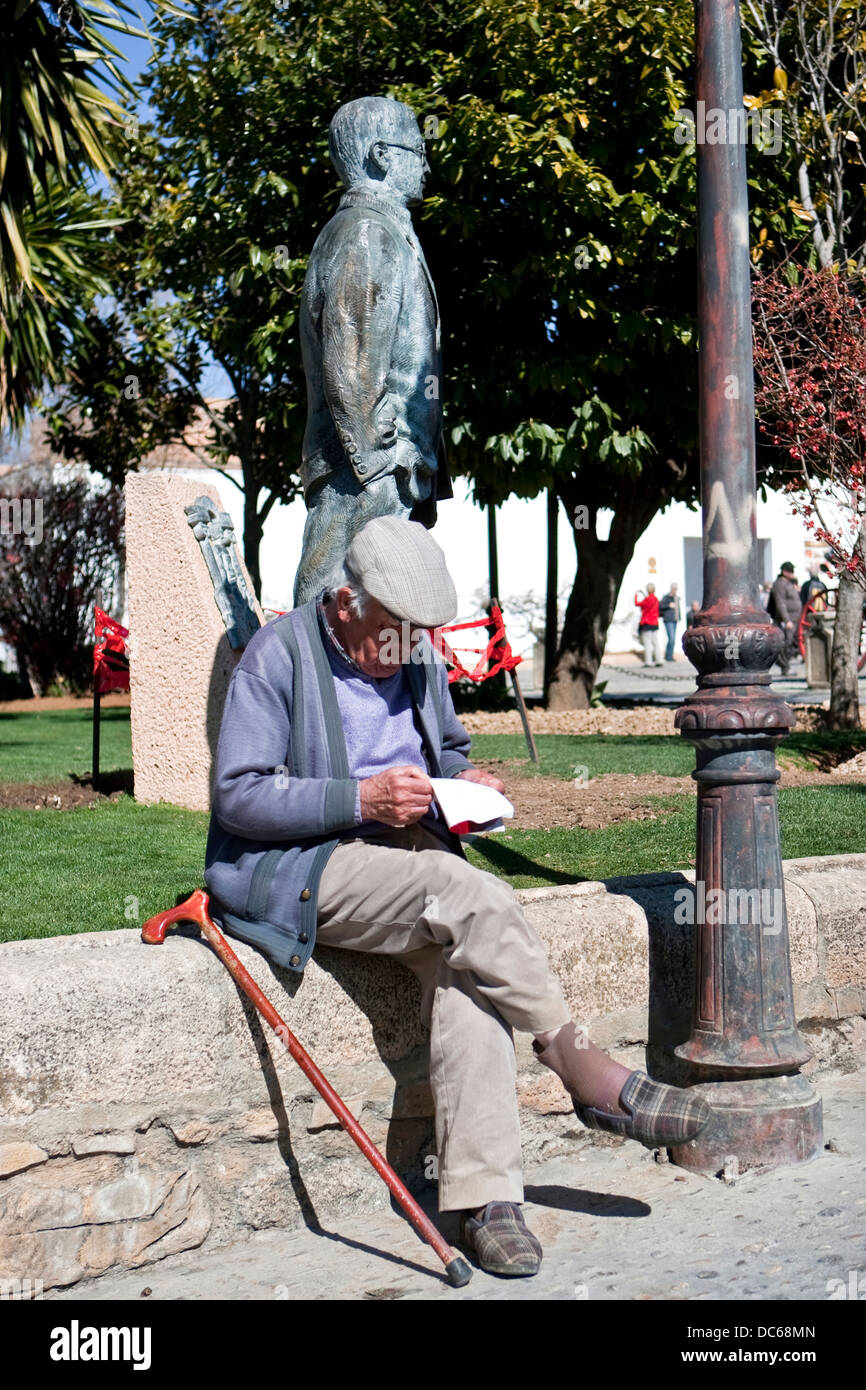 Old man reading relaxing in the Park next to the statue of Blas Infante in Ronda, Malaga Province, Andalucia, Spain Stock Photo