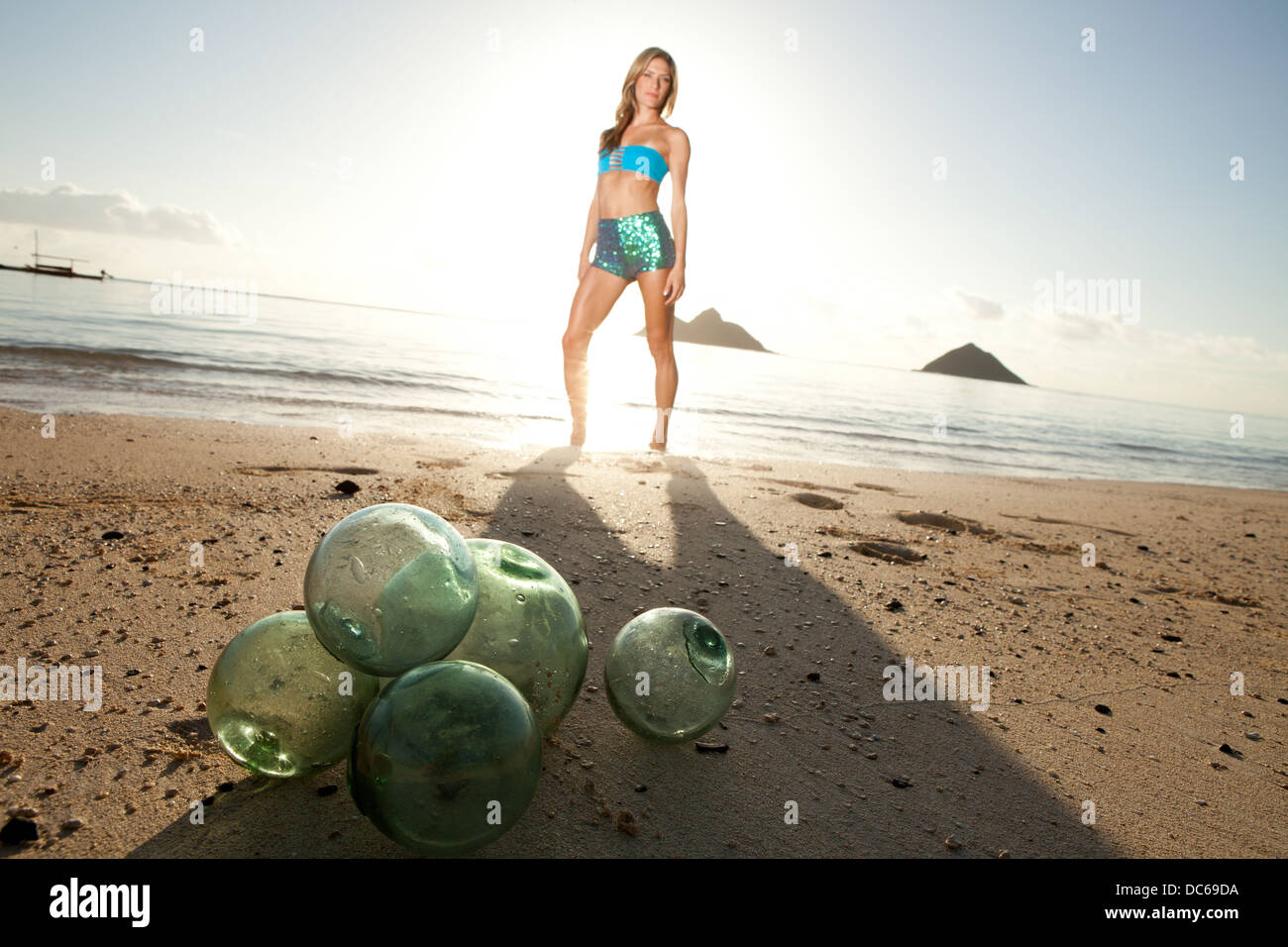 A woman on Lanikai Beach with her glass fishing buoys. Stock Photo