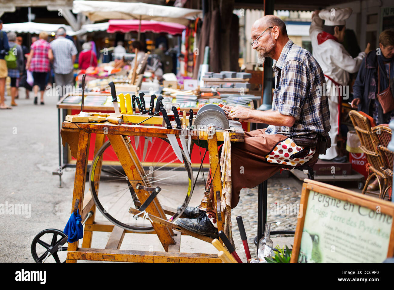 man sharpening knives in a French market Stock Photo