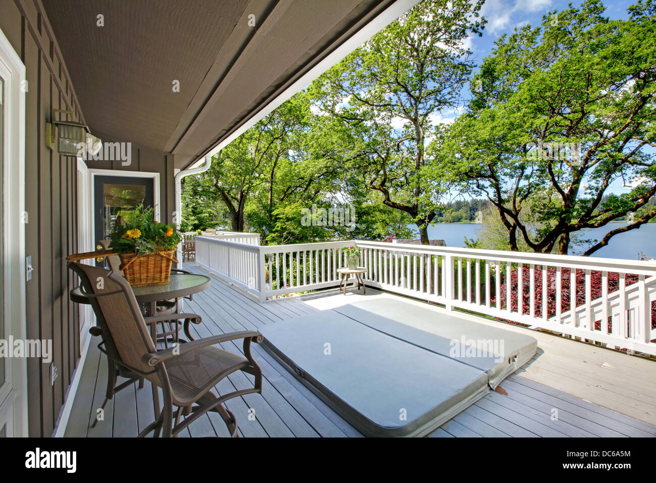 Large long balcony home exterior with hot tub and chairs, lake view Stock Photo Alamy