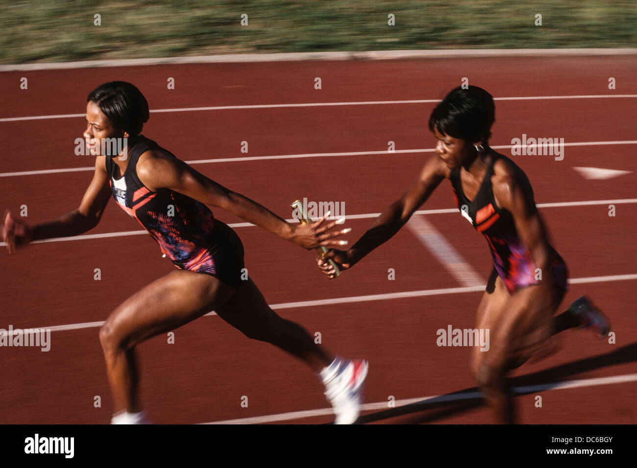 Women's track and field relay team baton pass Stock Photo Alamy