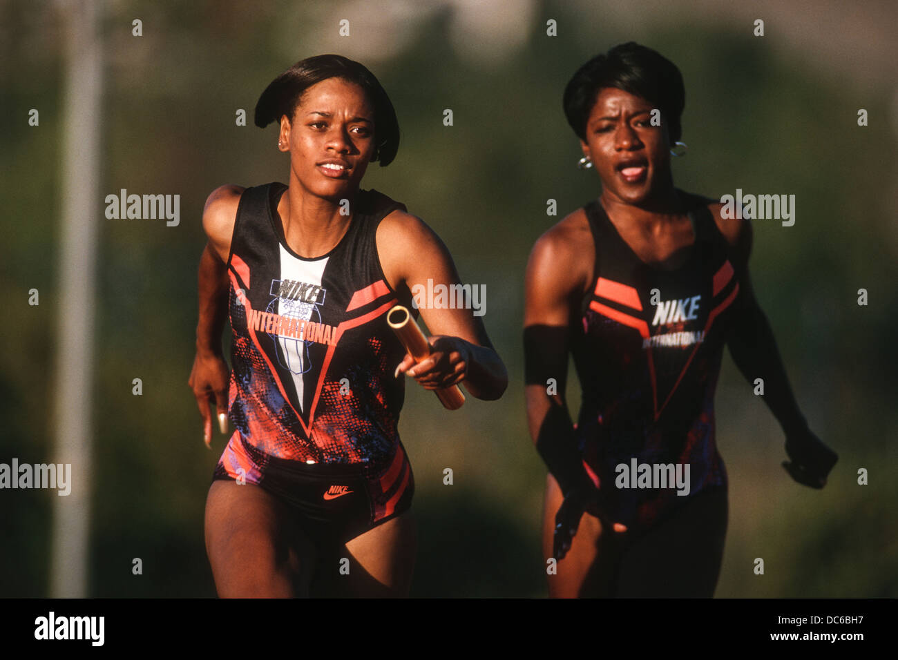 Women's track and field relay team baton pass Stock Photo Alamy