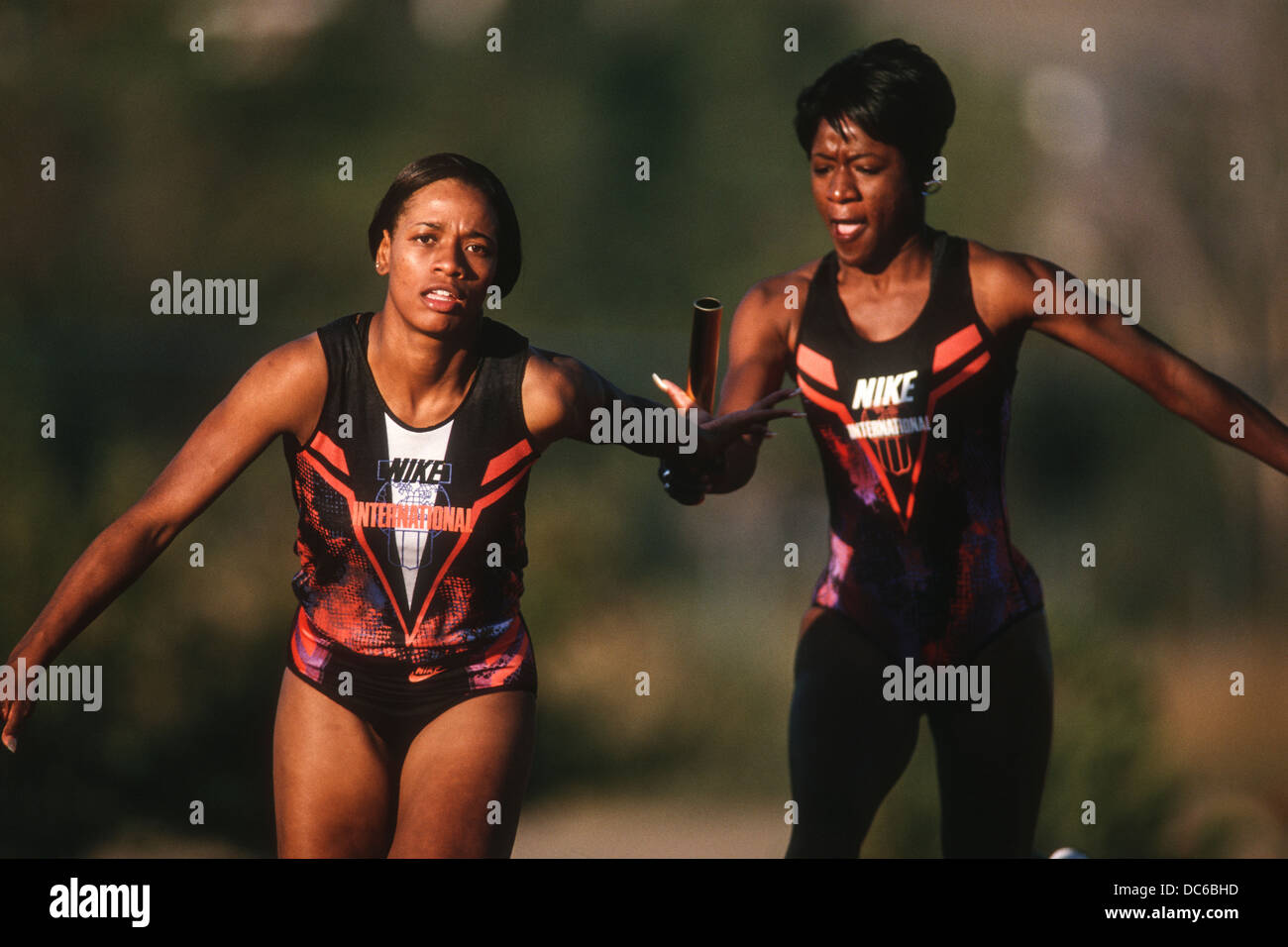 Women's track and field relay team baton pass Stock Photo Alamy