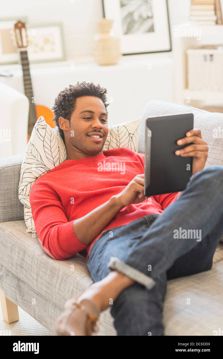 Man Lying On Sofa And Using Tablet Pc Stock Photo Alamy