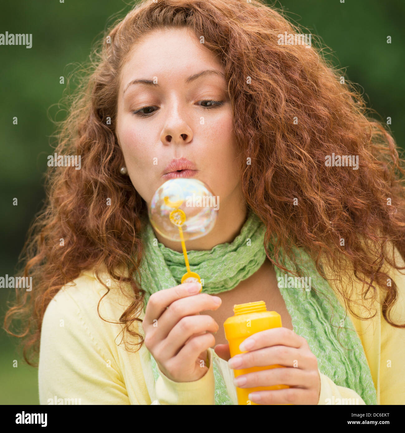 Young woman blowing bubbles in park Stock Photo Alamy