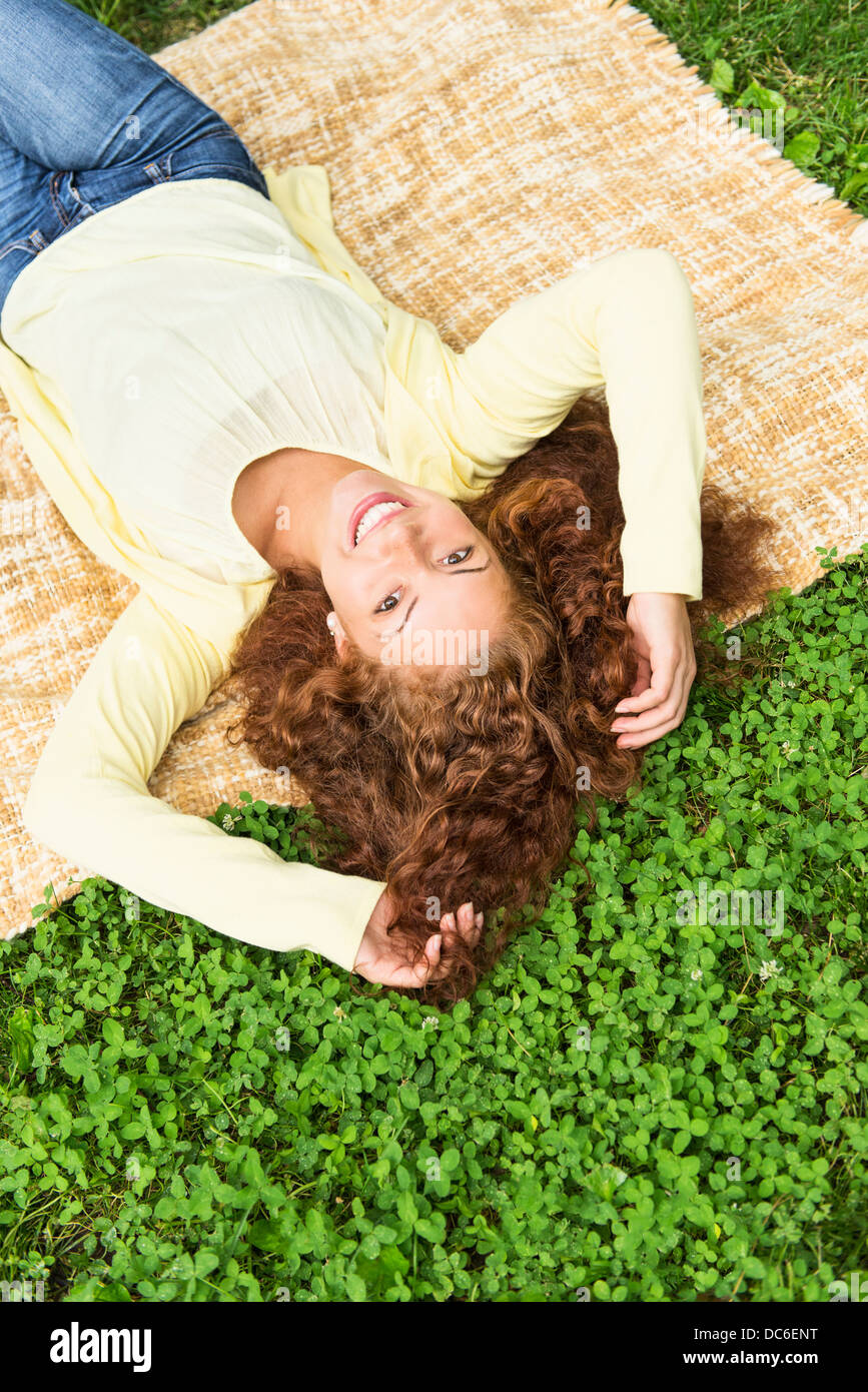 Woman lying on grass in park Stock Photo - Alamy