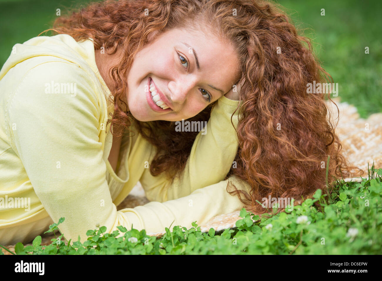 Woman lying on grass in park Stock Photo - Alamy