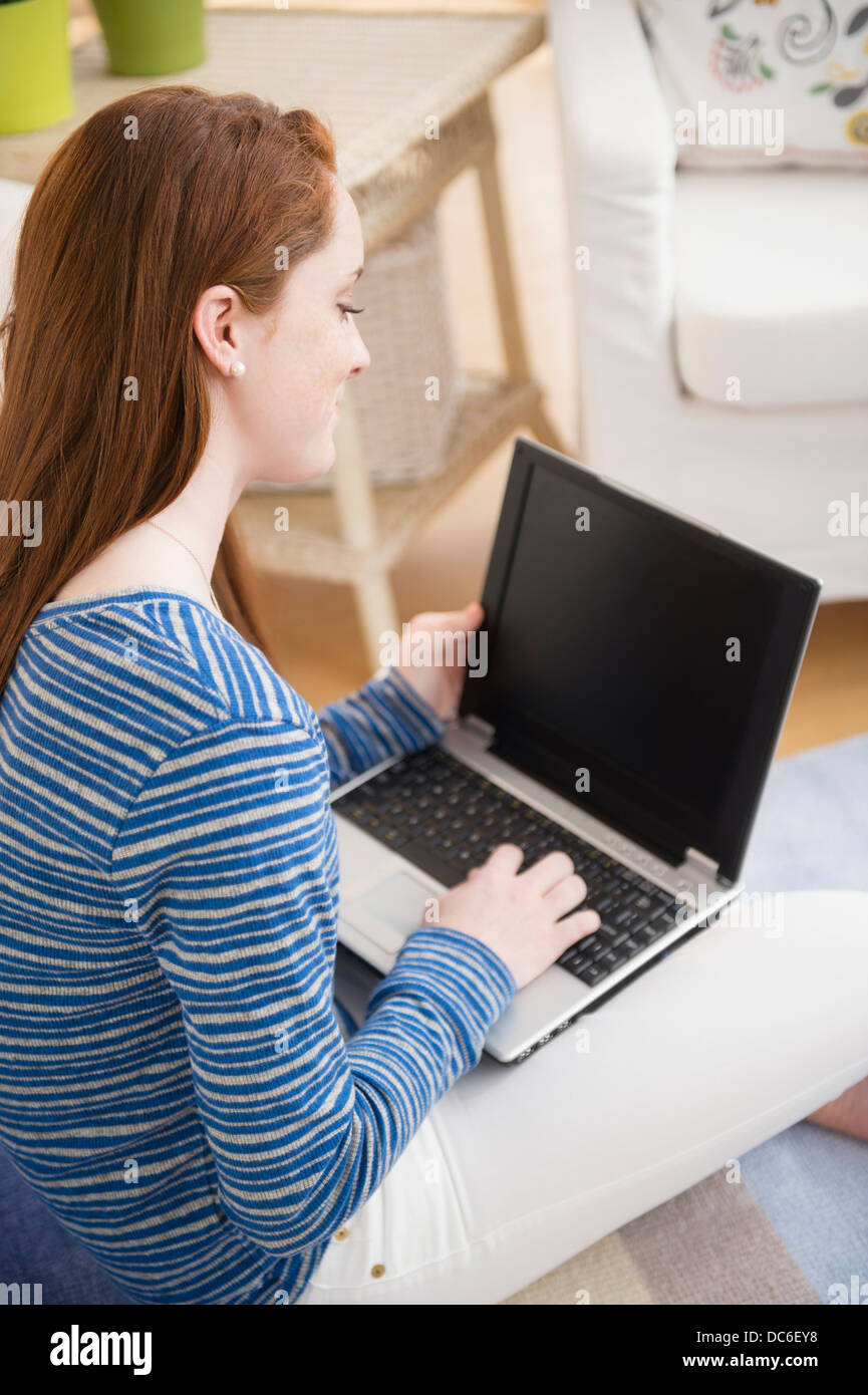 Teenage girl (14-15) studying with laptop Stock Photo