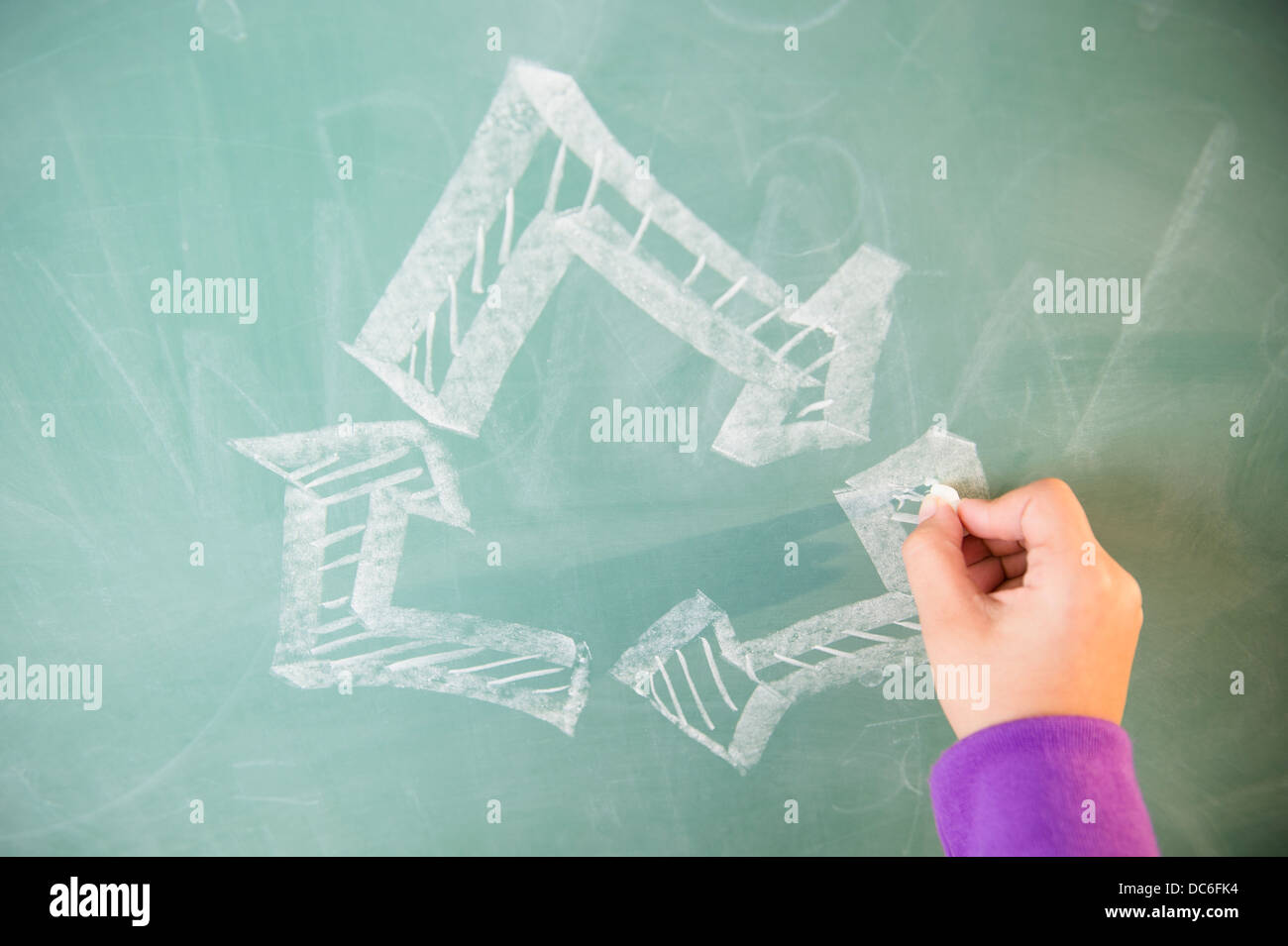 View of arrows on blackboard and girl's hand Stock Photo