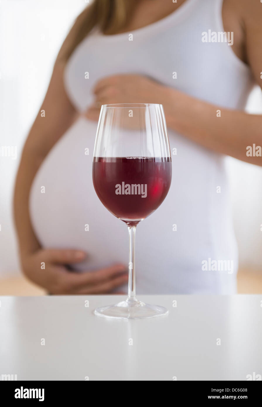 Mid section of pregnant woman, red wine in front Stock Photo Alamy