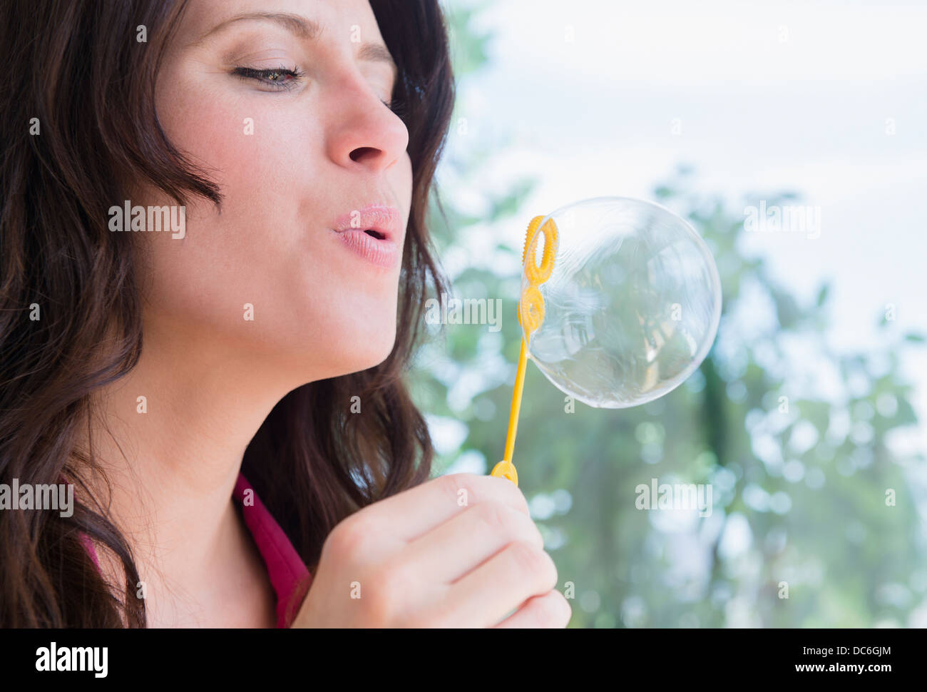 Portrait of woman blowing bubble Stock Photo