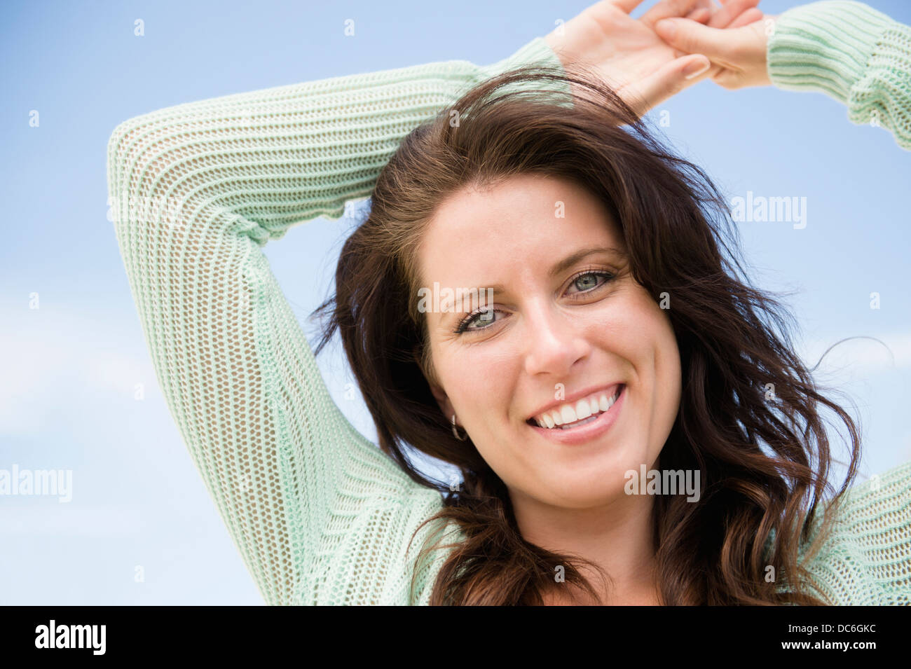 Happy woman against blue sky Stock Photo - Alamy