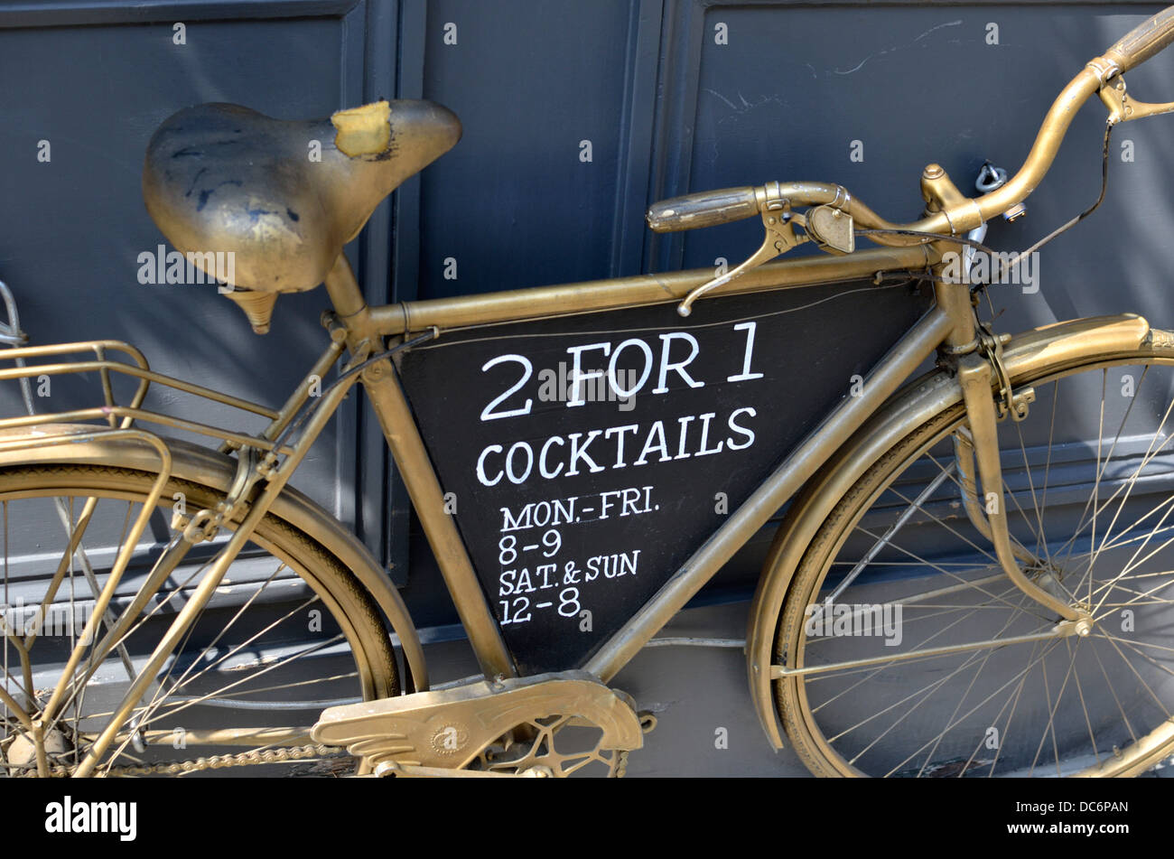 '2 for 1 Cocktails' sign on an old bicycle outside a bar, London, UK Stock Photo