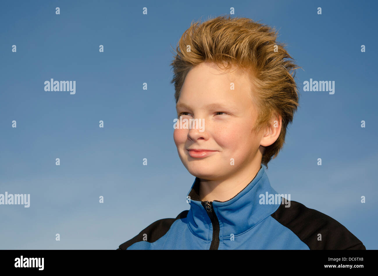Portrait of guy with spiky hairstyle against blue sky Stock Photo