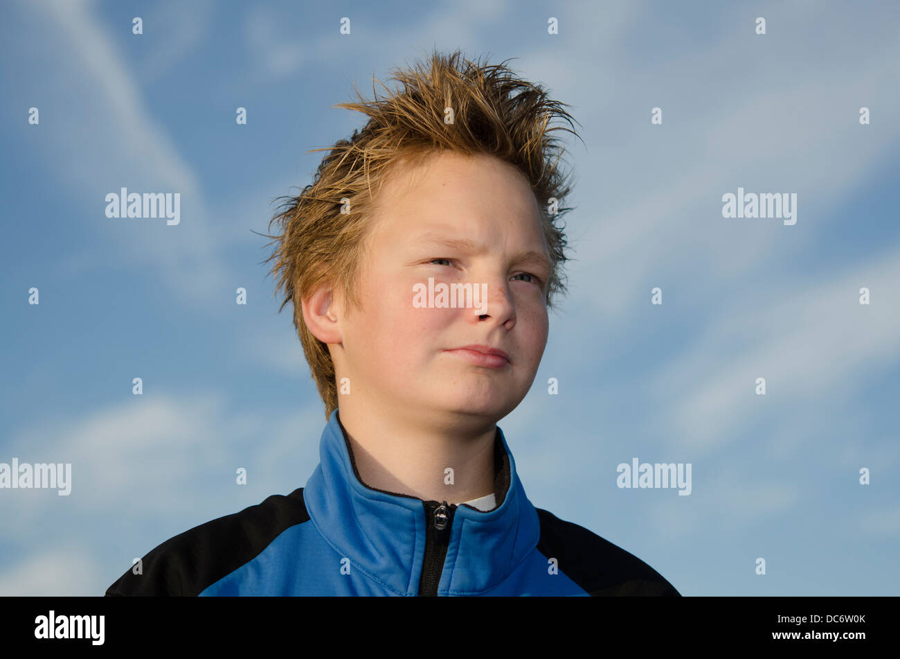 Portrait of teenager with spiky hair against blue sky Stock Photo