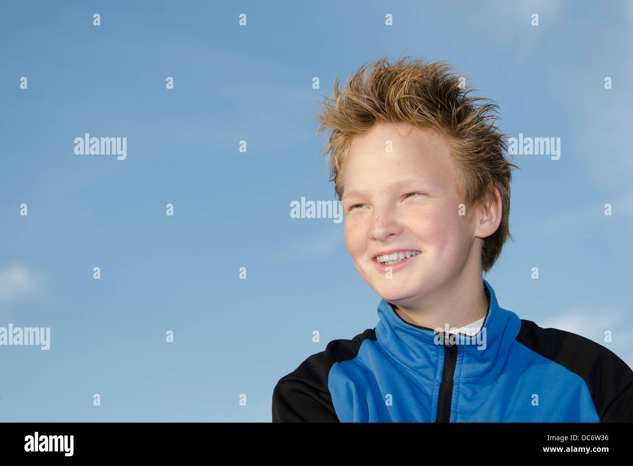 Portrait of happy teenager with spiky hairstyle against sky Stock Photo