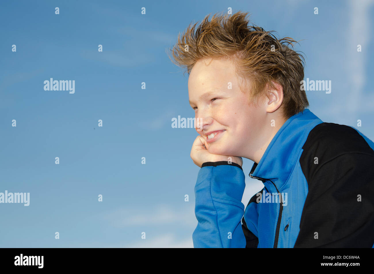 Portrait of guy with spiky hairstyle against blue sky background Stock Photo