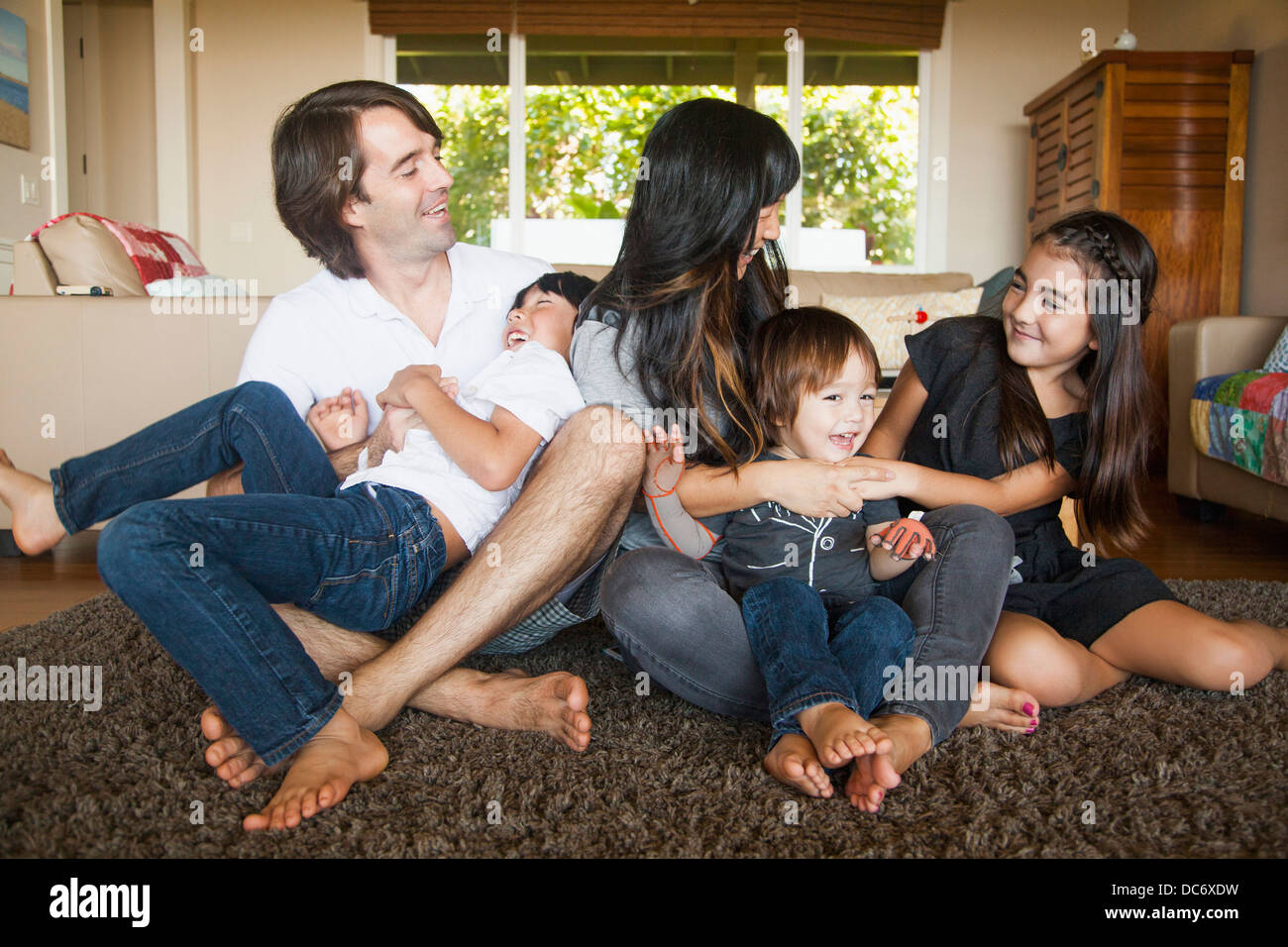 Portrait of family sitting in living room Stock Photo