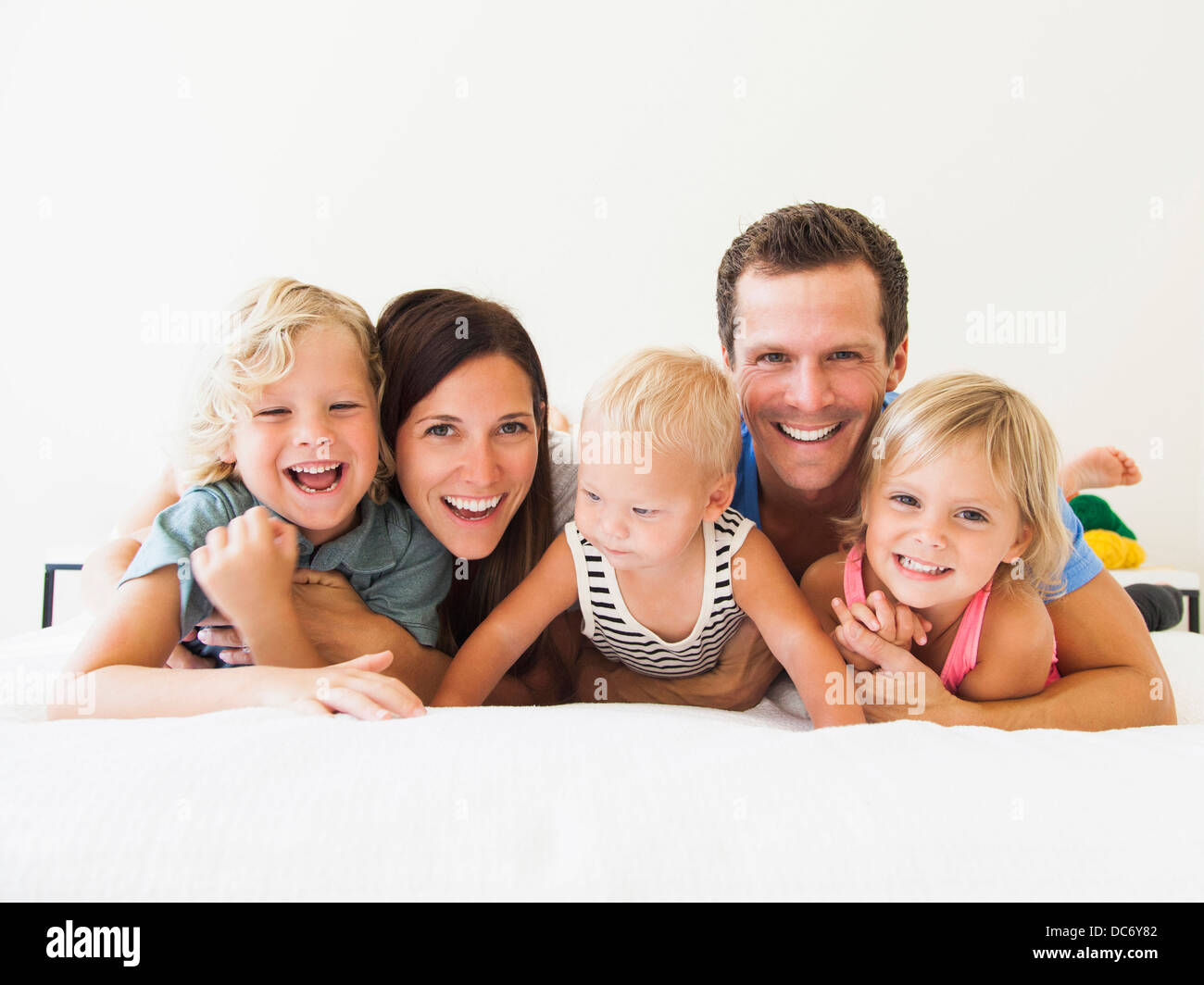 Portrait of family with three kids (6-7, 2-3, 6-11 months) Stock Photo