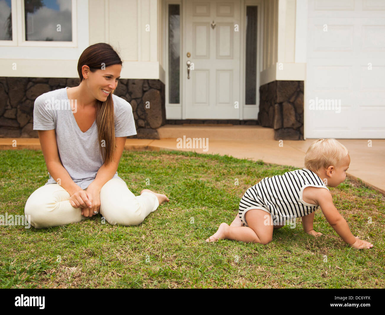 USA, Hawaii, Kauai, Mother with baby boy (6-11 months) in front of house Stock Photo