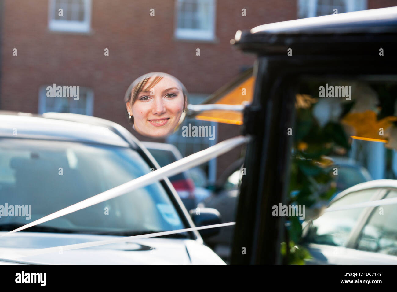 Brides face reflected in round car mirror on wedding day lady smiling reflection Stock Photo