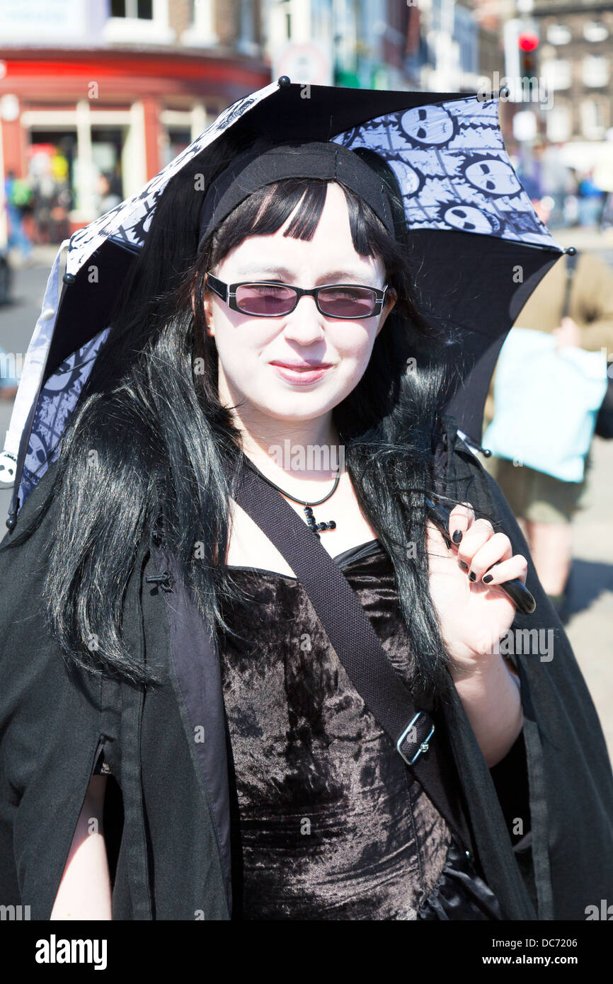 Teen heavy metal fan with umbrella posing emo goth gothic in Whitby Yorkshire UK England Stock Photo