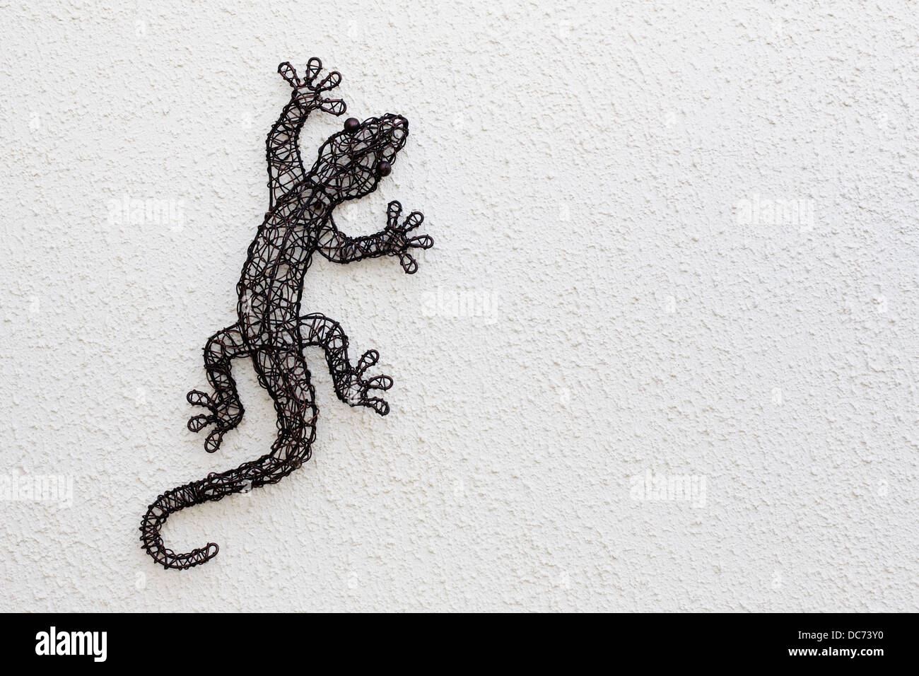 Wire lizard sculpture on a white textured wall Stock Photo - Alamy