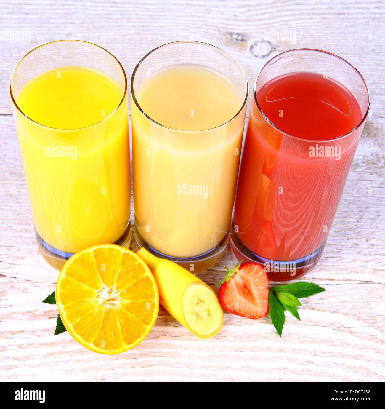 Oranges, bananas, strawberry slice, juice in glass, top view Stock