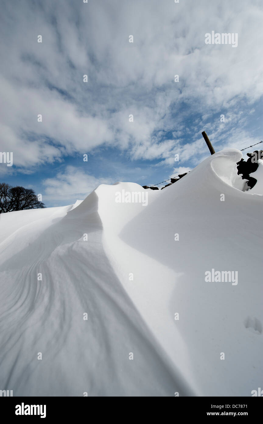 Patterns formed in snowdrifts at the back of drystone walls, Cumbria, UK Stock Photo