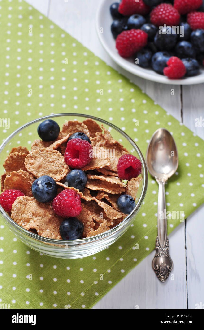 cereal flakes with raspberry and blueberry in glass bowl Stock Photo