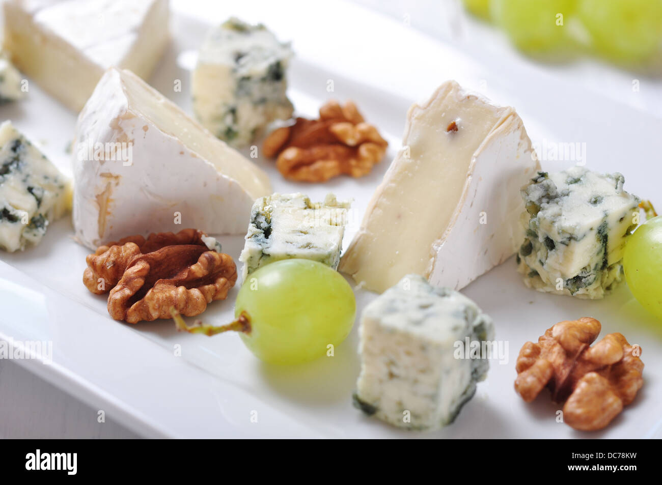 Camembert and blue cheese on plate with grape and walnut closeup Stock Photo