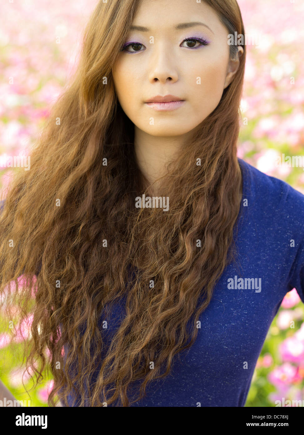 Beautiful Japanese girl in field of cosmos flowers, Kin Town, Okinawa, Japan Stock Photo