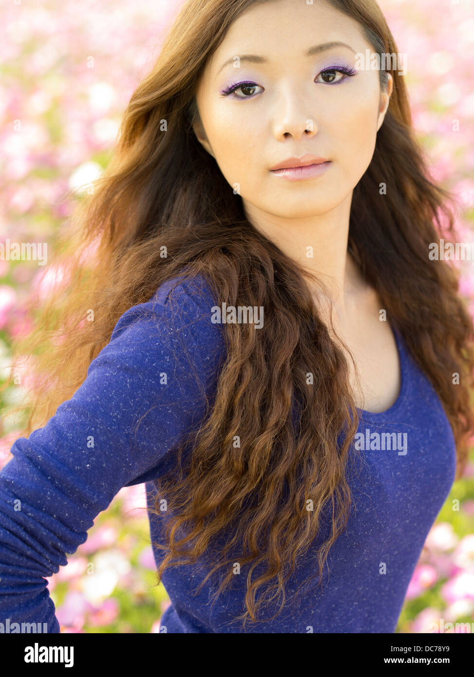 Beautiful Japanese girl in field of cosmos flowers, Kin Town, Okinawa, Japan Stock Photo