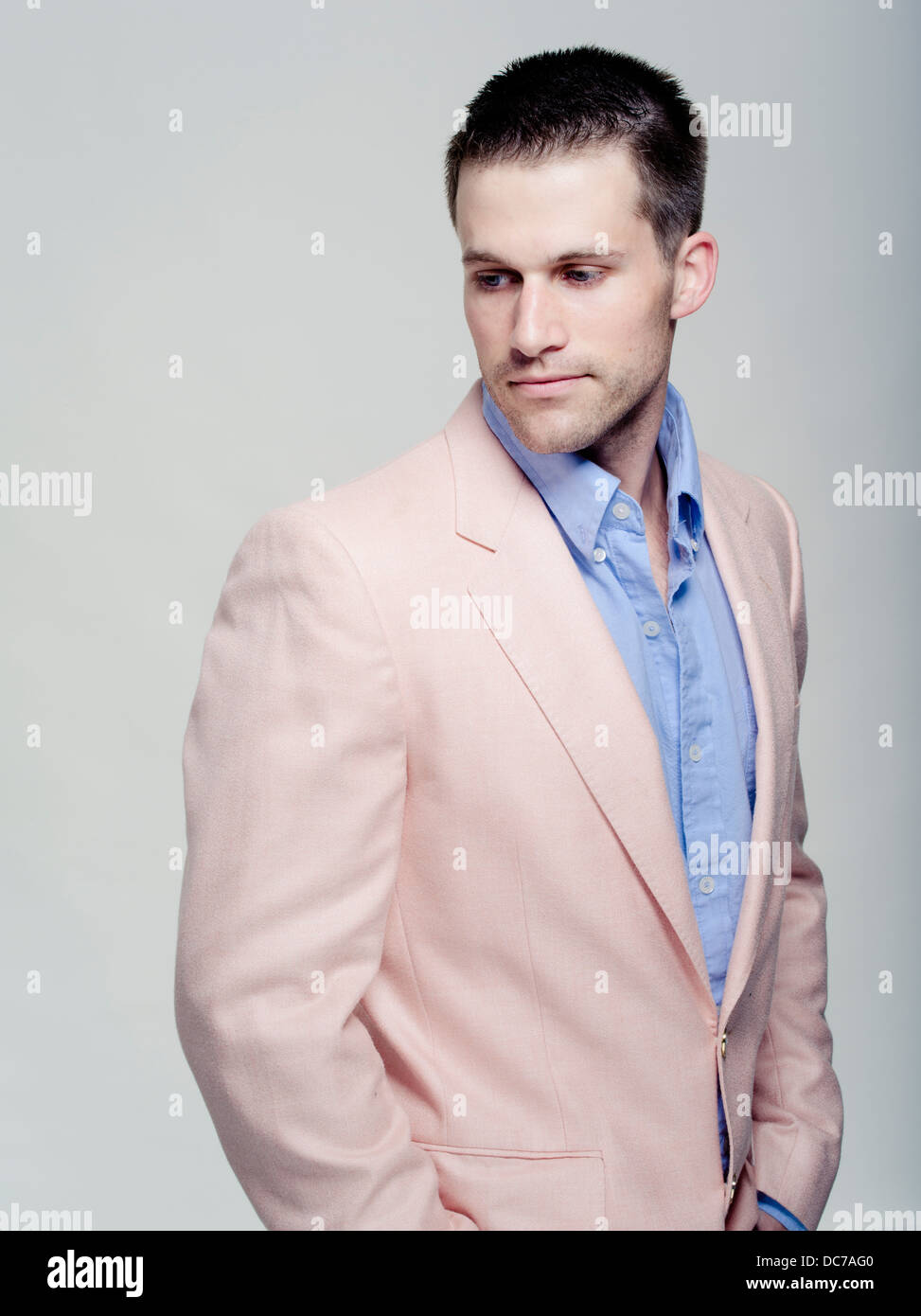 Handsome Caucasian man in his wearing baby blue shirt and pink jacket Stock Photo