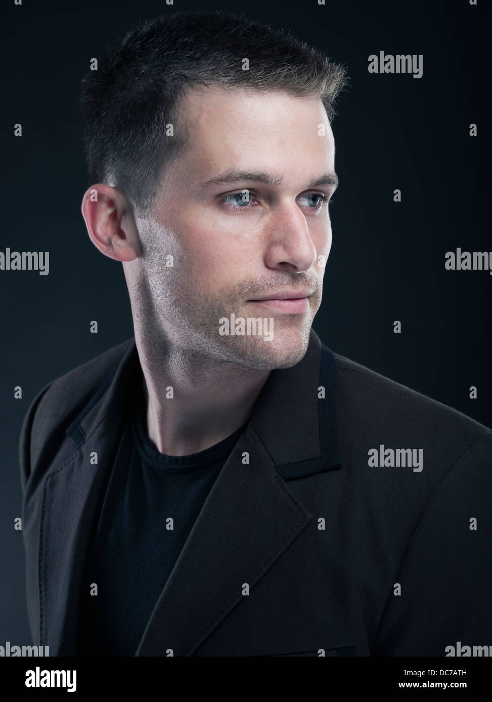 Handsome Caucasian man in his twenties wearing black t-shirt and jacket Stock Photo