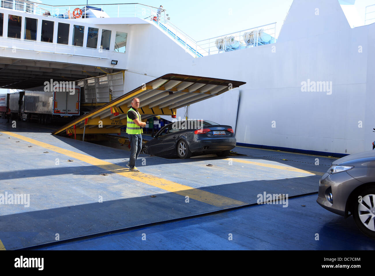 Cars being directed into a low level car park on a Greek ferry Stock Photo