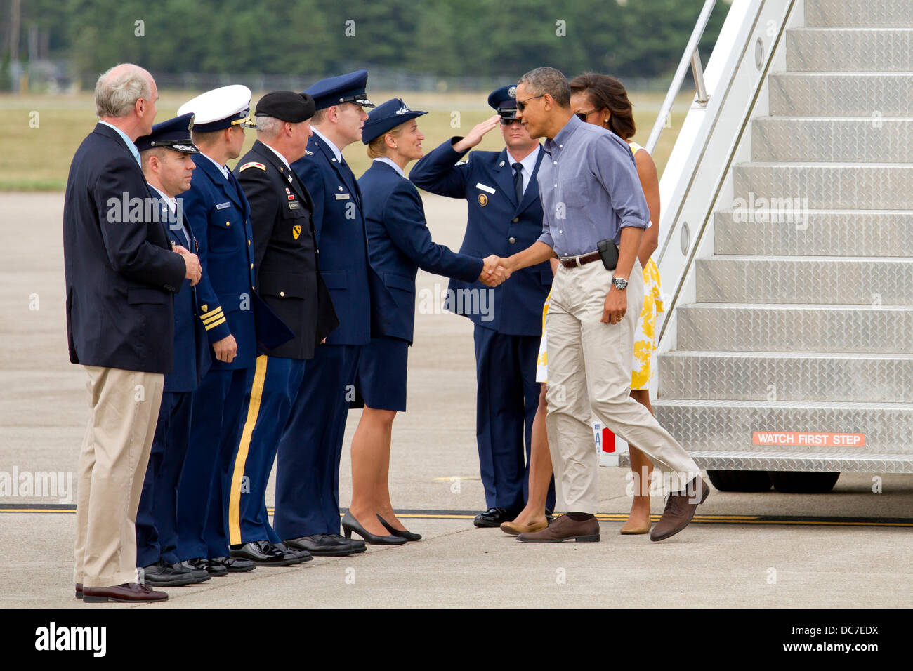 US President Barack Obama greets base commanders after landing aboard Air Force One at Joint Base Cape Cod August 10, 2013 in Buzzards Bay, MA. The Obama's are on their way to Martha's Vineyard for summer vacation. Stock Photo
