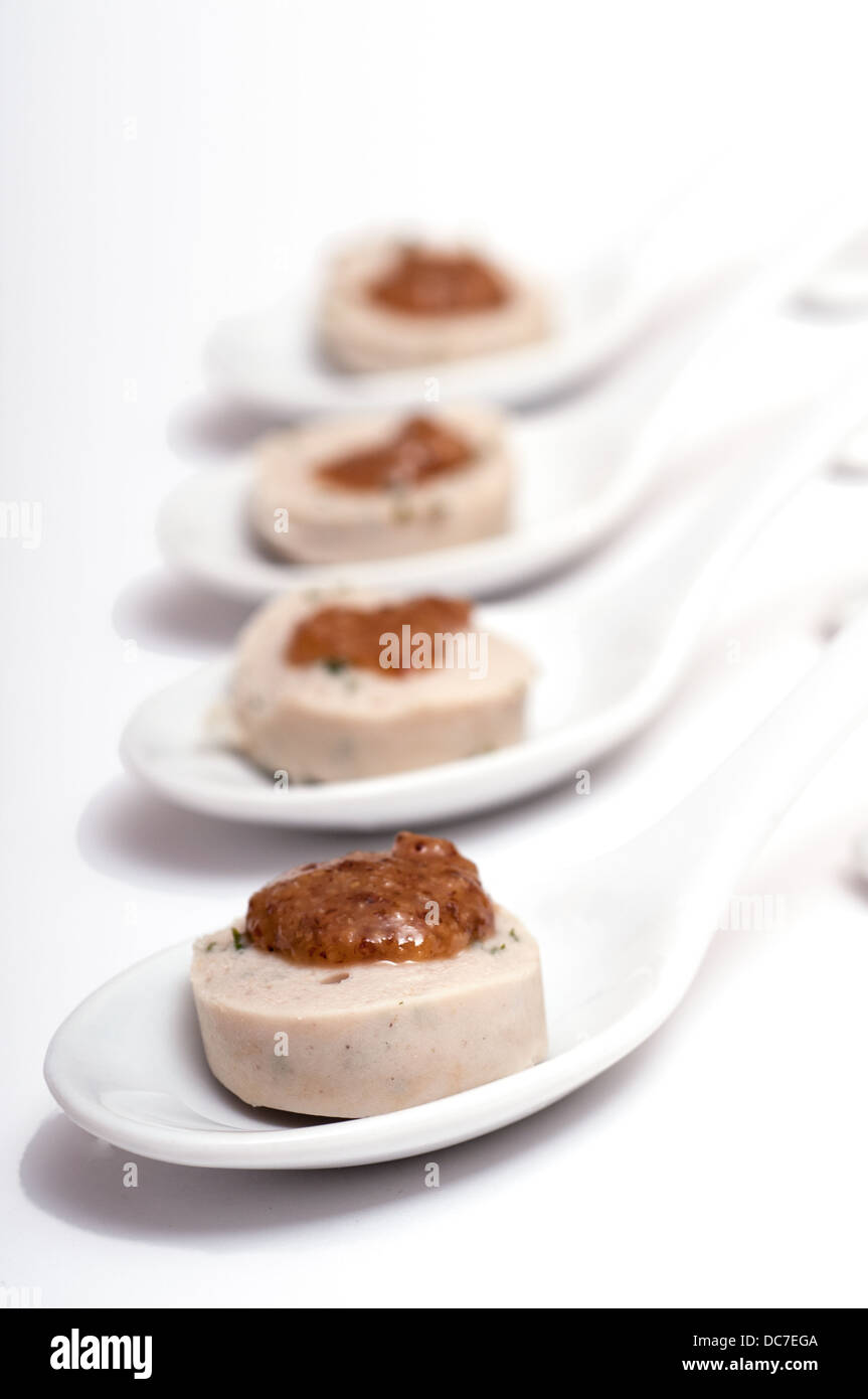 Four spoons with a bavarian veal sausage and sweet mustard Stock Photo