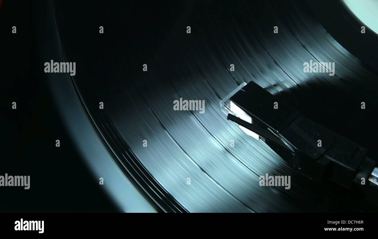 A black vinyl LP record playing on a turntable. Stock Photo