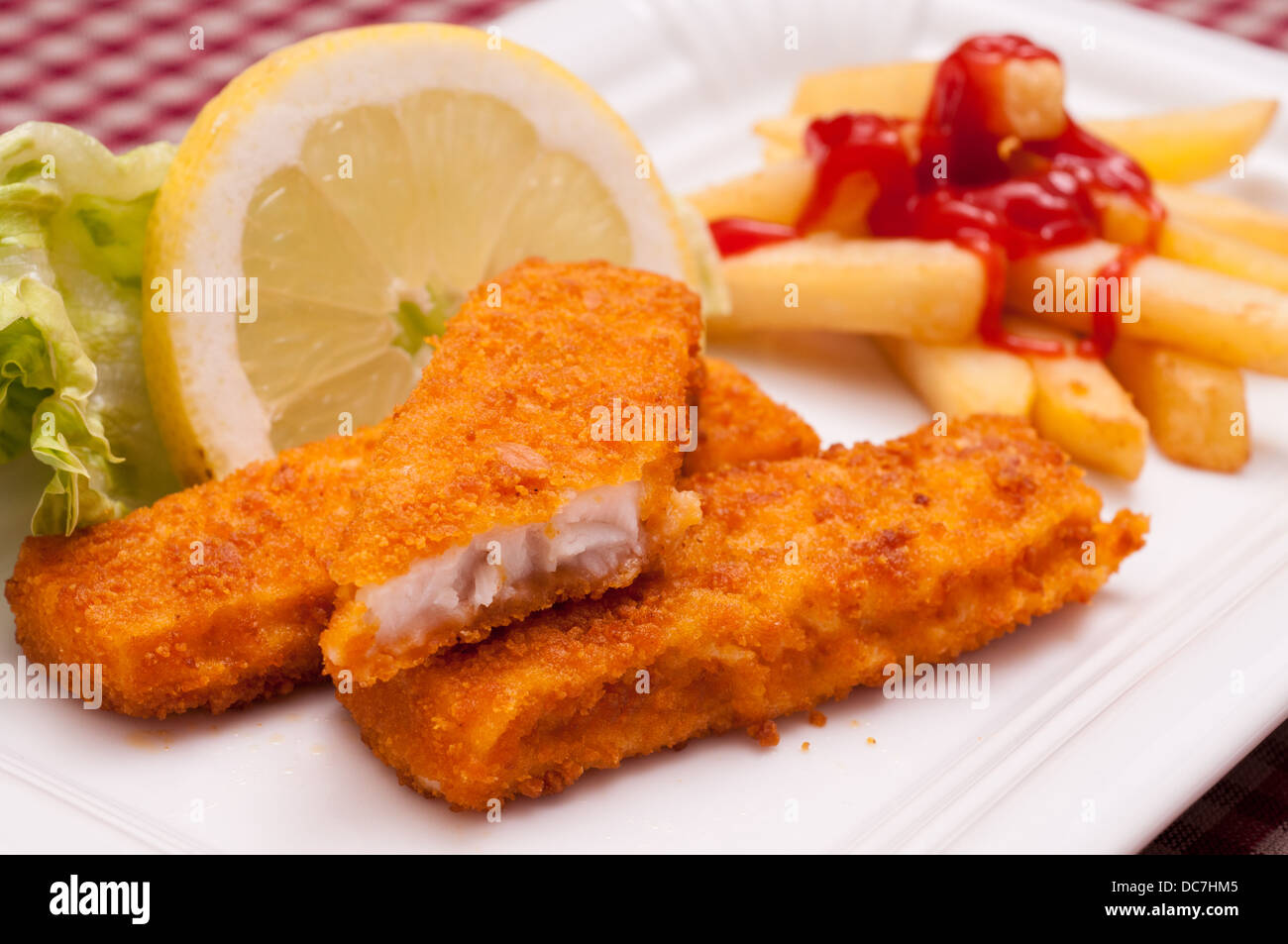 Breaded fish sticks with french fries and ketchup and lemon Stock Photo