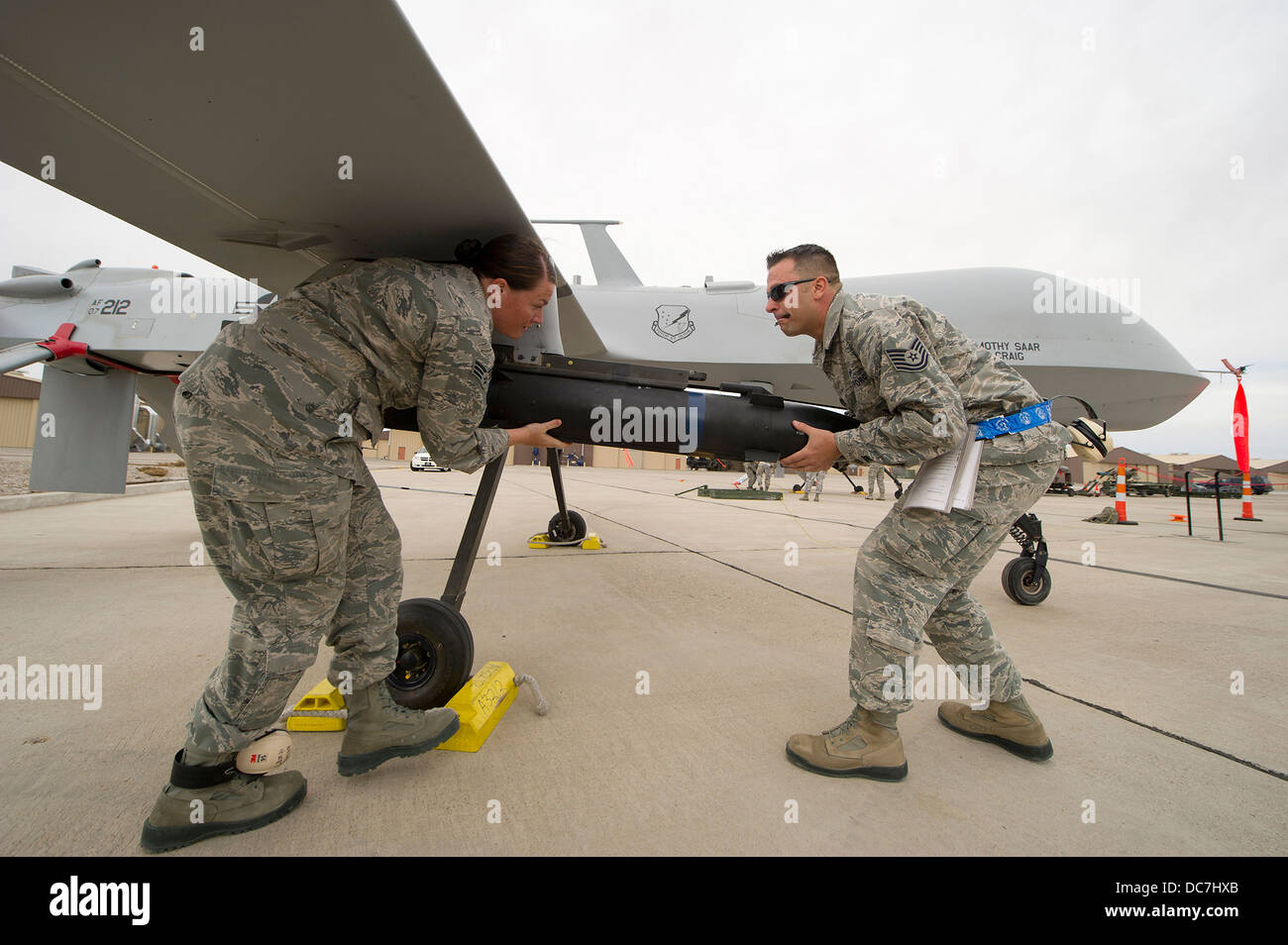 US Air Force airmen load a missile onto a MQ-1 Predator unmanned aerial drone April 5, 2013 at Holloman Air Force Base, NM. Stock Photo